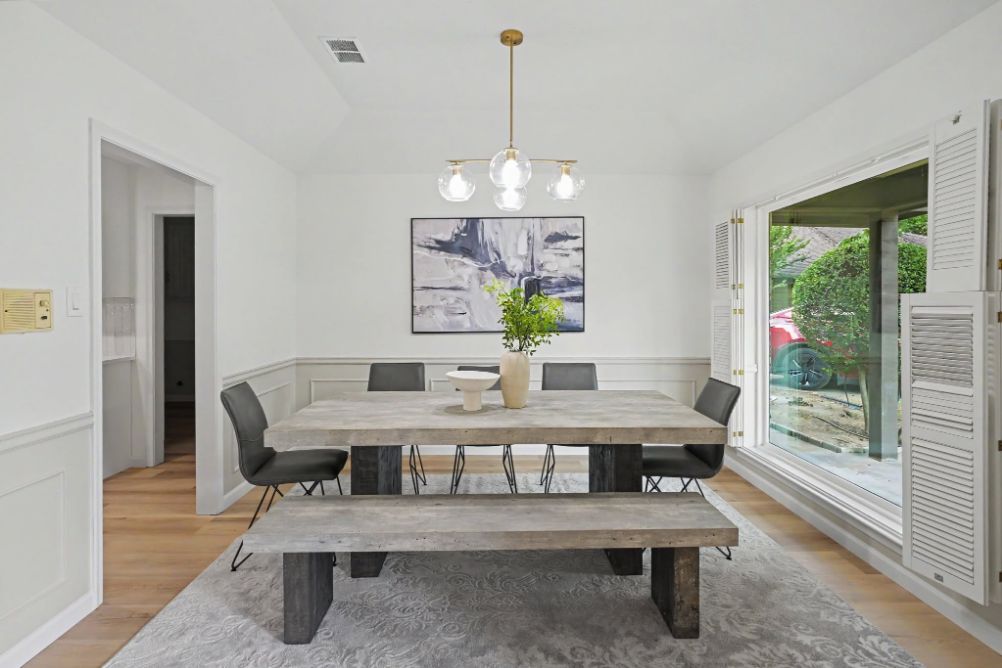 Formal dining room staged with a natural wood table and black chairs