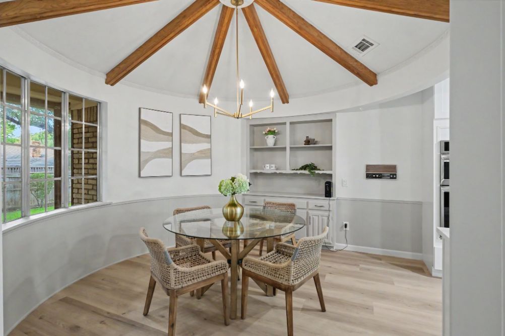 Breakfast room with vaulted wood beams and woven dining chairs