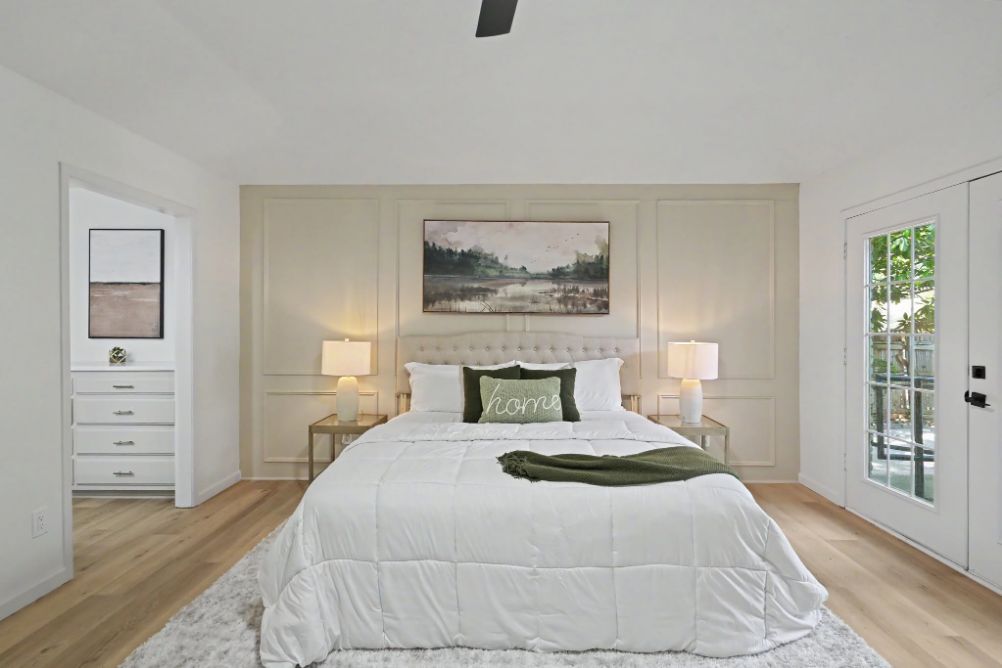 Peaceful primary bedroom staged in cream and olive green