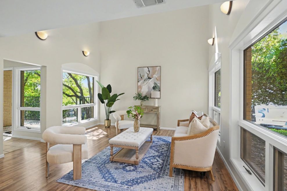 Second view of the sunlit sitting room with large windows