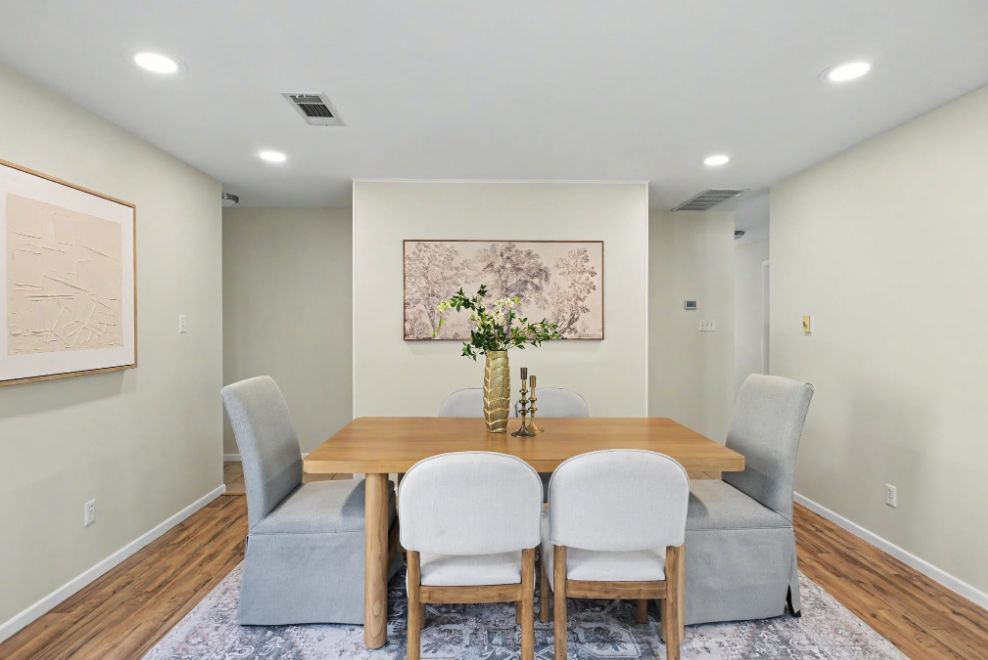 Formal dining room staged with a natural wood table and soft gray chairs