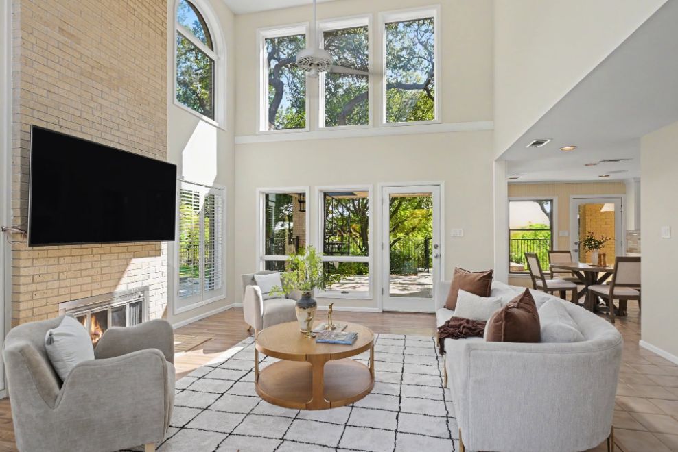 Open living room staged beneath a dramatic wall of windows