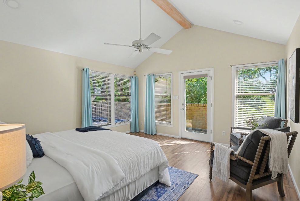 Vaulted bedroom staged with soft blue textiles and lounge chairs