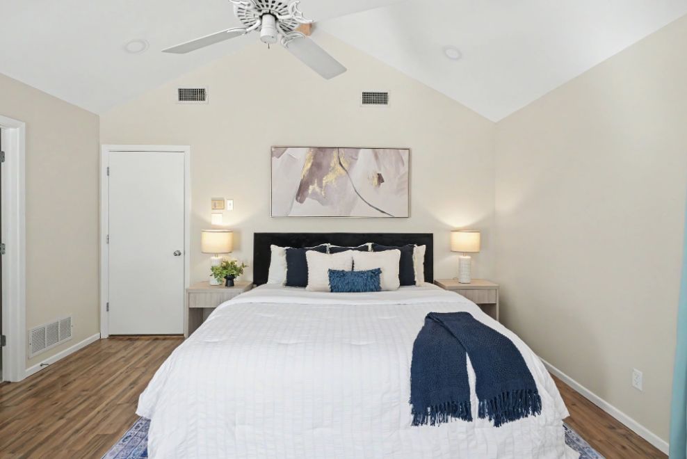Staged bedroom with navy blue accents and vaulted ceiling