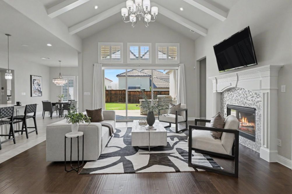 Staged open living room with fireplace and dining area