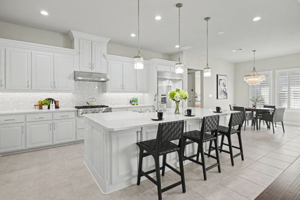 Bright white kitchen with a staged island and dining area