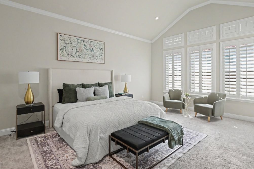 Primary bedroom staged in soft neutral tones