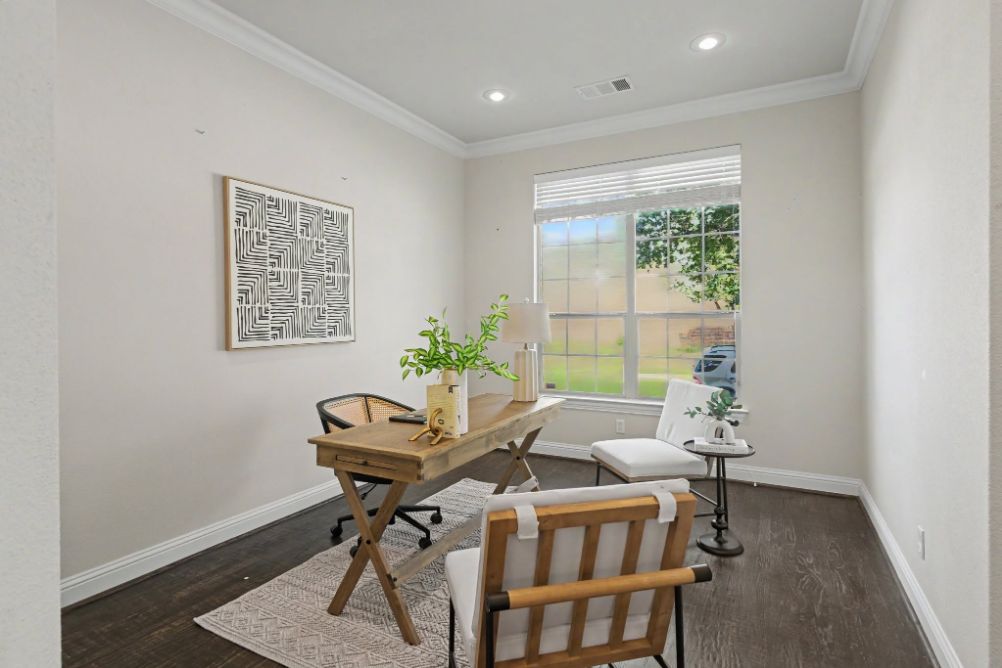 Bright home office staged with a wood desk and neutral seating