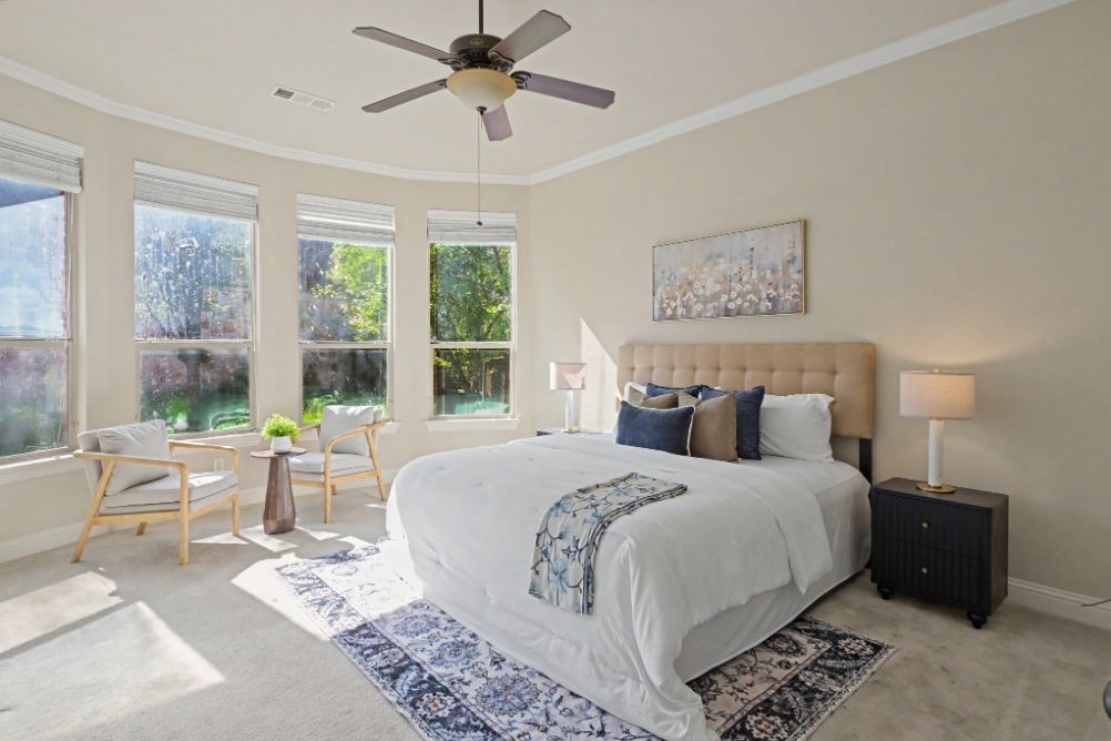 Sunlit primary bedroom staged with blue and ivory accents